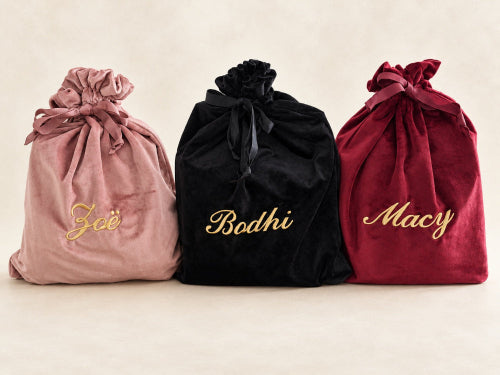 Gepersonaliseerde velvet cadeauzakken in oudroze, zwart en bordeauxrood met gouden geborduurde namen